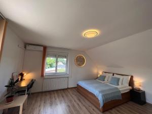 um quarto com uma cama, uma secretária e uma janela em Garden villa em Budapeste