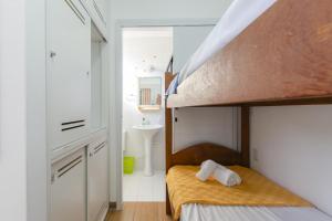 Dormitorio pequeño con litera y lavabo en Apartamento pé na areia em condomínio com piscina N1298, en Florianópolis