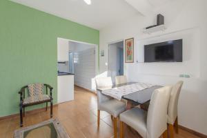 cocina y comedor con mesa y sillas en Apartamento pé na areia em condomínio com piscina N1298, en Florianópolis