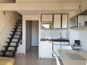 a kitchen with white cabinets and a staircase at Appartement climatisé à 800m de la plage in Fréjus