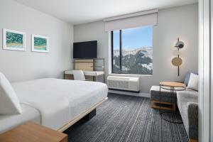 TownePlace Suites by Marriott Avon Vail Valley في آفون: غرفه فندقيه بسرير ونافذه