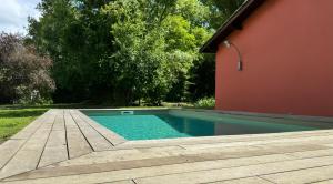 a swimming pool next to a house with a wooden deck at Château à Toulouse in Fenouillet