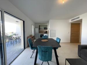 a dining room and living room with a table and chairs at T2 dans une résidence neuve avec piscine in Calvi +9 photos