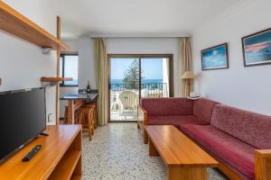 salon z kanapą i telewizorem z płaskim ekranem w obiekcie Los Ficus, Maspalomas w mieście Playa del Ingles