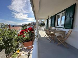 a balcony of a house with a table and chairs at Guest House KovacevicA in Hvar