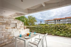 a table and chairs on the patio of a building at Villa Hanioti Dream seafront in Hanioti +38 photos