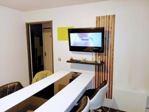 a room with a table and a tv on a wall at Le Loft in Montpellier
