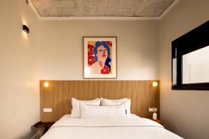 een slaapkamer met een bed en een schilderij aan de muur bij Savanna Dizengoff - Smart Hotel by Loginn Tel Aviv in Tel Aviv