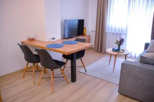 een woonkamer met een houten tafel en stoelen bij Apartman Mona in Teslić
