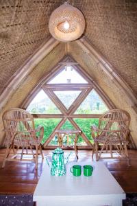 a room with a table and chairs and a large window at Villa ChavaMinerva Bambu - Lembang in Cikareumbi 2