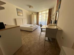 Apartments Aheloy Palace في أهيلوي: غرفة بسرير وطاولة وكراسي