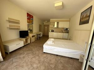 een slaapkamer met een wit bed en een keuken bij Apartments Aheloy Palace in Aheloy