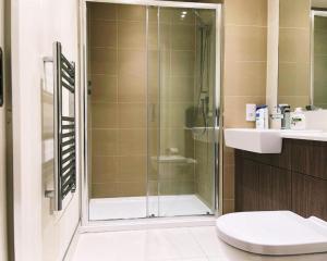 a bathroom with a shower and a toilet and a sink at Jenny's Place in Hendon