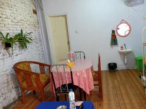 a dining room with a pink table and chairs at Sella Guest House in Banyuwangi