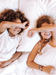 deux filles qui se couchent au lit avec les bras croisés dans l'établissement Pullman Lyon, à Lyon