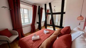 a bedroom with a red bed with two towels on it at Appartement Le Verdoyant hyper centre avec Parking et Sauna in Colmar