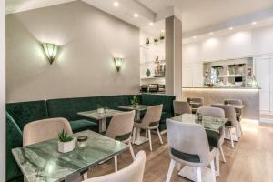 ein Restaurant mit einer grünen Couch sowie Tischen und Stühlen in der Unterkunft Hotel Sorrento City in Sorrent