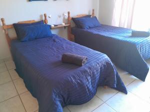 - une chambre avec 2 lits avec des couettes bleues et un oreiller dans l'établissement Sweet Dreams Polokwane, à Polokwane