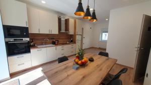 a kitchen with a wooden table with a bowl of fruit on it at Apartments Seventy Seven in Kranjska Gora