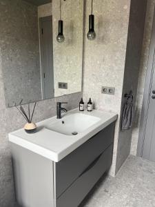 Un baño con un lavabo blanco y un espejo. en Luxury Beach Villa, en Adeje