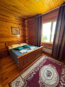 a bedroom with a bed in a wooden cabin at Mayak Resort in Kam”yani Potoky