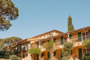 an old building with trees in front of it at Hôtel Villa Marie Saint Tropez in Saint-Tropez