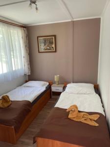 2 posti letto in camera con asciugamani di Panoráma Nyaraló a Tahitótfalu