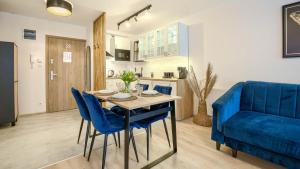 a living room with a table and a blue couch at Baltic Residence, Sun & Snow in Pobierowo