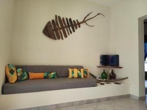 Casa Djarmai Boutique Apartments في فيلا دو مايو: أريكة على جدار مع فرع على الحائط