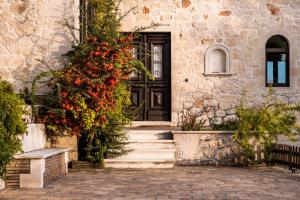 dom z czarnymi drzwiami i kwiatami w obiekcie Alexandros Stone Villa w mieście Ágios Nikólaos