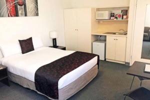 a hotel room with a large bed and a kitchen at 259 Gouger city unit 105 in Adelaide +21 photos