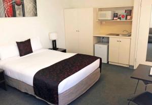 a hotel room with a large bed and a kitchen at 259 Gouger city unit 105 in Adelaide