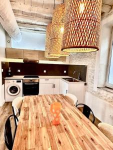 a kitchen with a wooden table with chairs and a kitchen with a stove at Pierre Lauragaise in Avignonet-de-Lauragais +4 photos