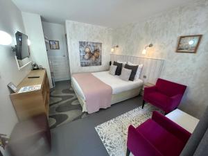 a hotel room with a bed and a red chair at Hôtel Monet in Honfleur