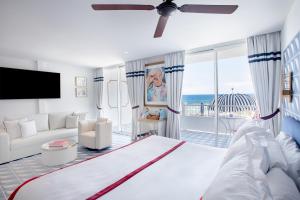 a bedroom with a large bed and a living room at Hotel Mongibello Ibiza in Santa Eularia des Riu