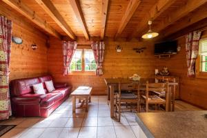 ein Wohnzimmer mit einem roten Sofa und einem Tisch in der Unterkunft Chalet indépendant 3 personnes in Alex