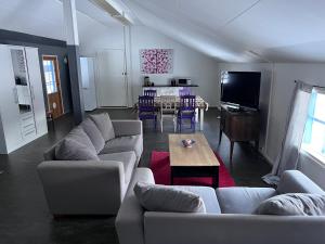 a living room with couches and a table and a television at Villa Aronia in Porvoo