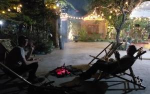 zwei Menschen sitzen nachts auf Stühlen um ein Feuer herum in der Unterkunft Tam Family Homestay in Ninh Bình
