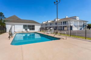 a swimming pool in front of a house at Baymont by Wyndham Brunswick GA in Brunswick