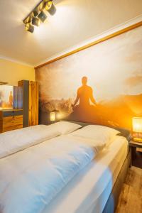 a bedroom with two beds and a painting on the wall at Hotel Plankl in Altötting