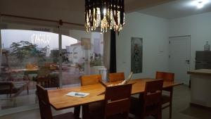 a dining room table with chairs and a chandelier at Casa Djarmai Boutique Apartments in Vila do Porto