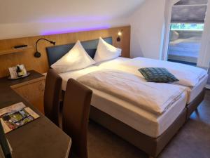 ein Schlafzimmer mit einem Bett und einem Tisch mit einer Lampe in der Unterkunft Dei Hotel Schönblick in Velden am Wörthersee