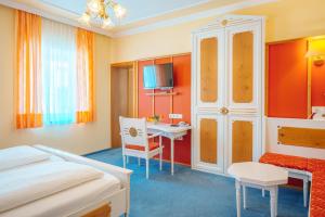 a hotel room with a bed and a desk at Hotel Plankl in Altötting