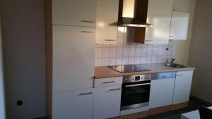 uma cozinha com armários brancos e um fogão em Fewo Sumbrink Bodenwerder em Bodenwerder