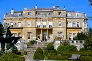 a large house with a statue in front of it at Luton Hoo Hotel, Golf and Spa in Luton