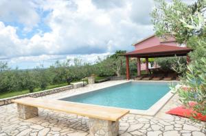 a swimming pool with a bench and a gazebo at Villa Vale in Labin