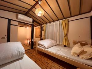 a bedroom with two beds and a window at Dormitory Omitsu in Nara