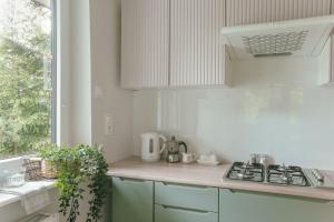 uma cozinha branca com um fogão e uma janela em Leśne zacisze - dom z kominkiem i balią em Jordanów