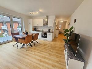 a kitchen and dining room with a table and chairs at EcoCube 442 - Balkon, 2Zimmer, Waschmaschine, Schlafsofa in Meppen