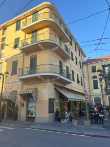 a yellow building with a balcony on the side of it at Albergo Florida Taggia in Taggia